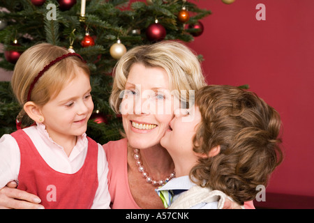 Grand-Mère embrassant petits-enfants la veille de Noël Banque D'Images