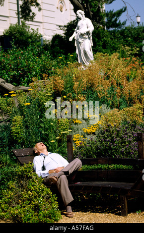 Bournemouth Dorset UK Russell Coates Art Gallery homme endormi dans le jardin sur le banc de parc Banque D'Images