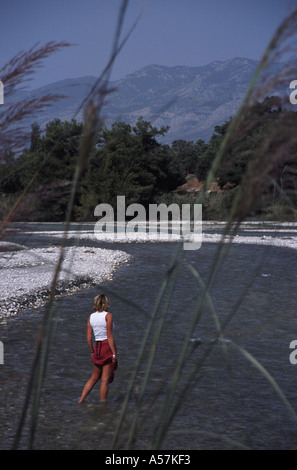 La LYCIE, LA TURQUIE. Une femme cools ses pieds dans la rivière à Saklikent, sur le chemin de Lycie, près de la Côte Turquoise. Banque D'Images