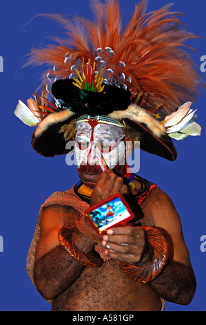 Un guerrier Huli peint son visage, Southern Highlands, Papouasie Nouvelle Guinée Banque D'Images