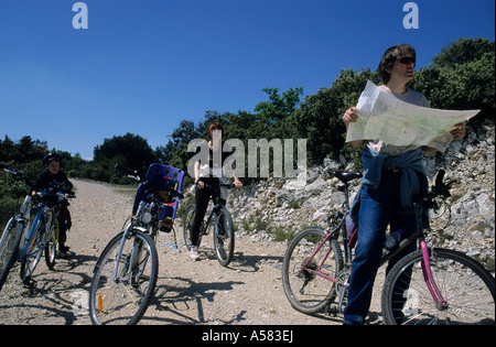 Famille de cyclistes s'arrêter pour vérifier leur chemin sur une carte. Banque D'Images