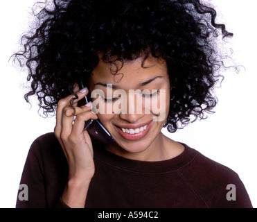 Jeune femme avec des cheveux bouclés Talking on Phone Banque D'Images