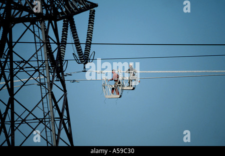 Hommes travaillant à la chariots suspendus de National Grid haute tension les câbles d'alimentation, UK Banque D'Images