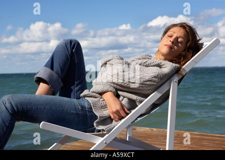 Femme en chaise pliante on Dock Banque D'Images