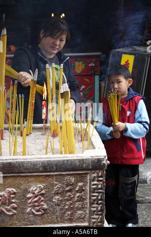 Le Temple A-Ma à Macao, la mère et le fils brûlent de l'encens Banque D'Images