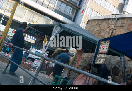 Un homme se fait couper les cheveux chez le coiffeur stall à Johannesburg Afrique du Sud Banque D'Images