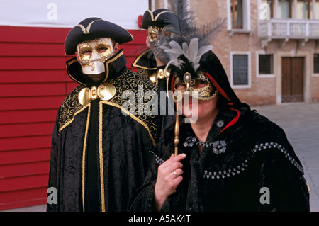 Les gens habillés en costumes de fantaisie et des masques vénitiens pendant le Carnaval de Venise Italie Banque D'Images