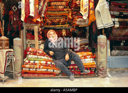 Un homme tapis vente takes a nap dans son magasin à Aleppo Syrie Souq Banque D'Images