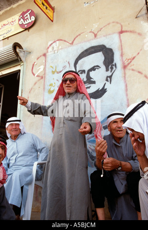 Collecte d'hommes avec une photo de Hafez Al Assad dans l'arrière-plan Banque D'Images