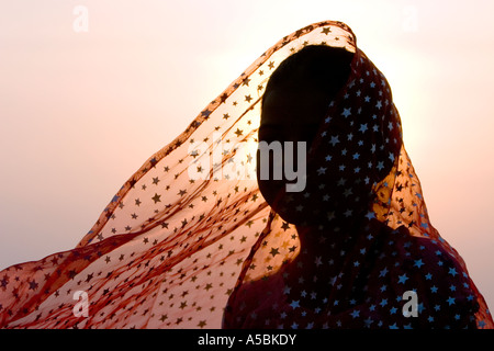 Jeune indienne portant voile star contre fond coucher de soleil. Silhouette. L'Inde Banque D'Images