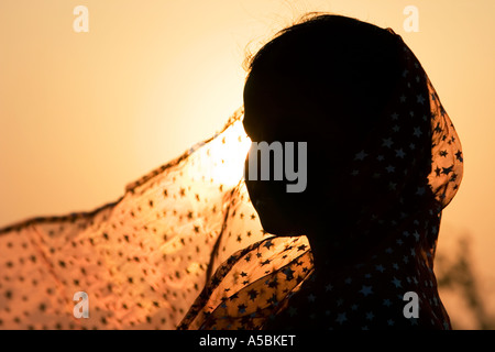 Jeune indienne portant voile star contre fond coucher de soleil. Silhouette. L'Inde Banque D'Images