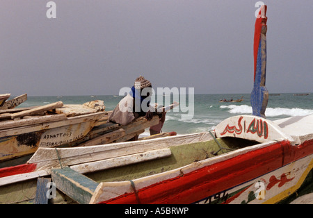 Pêcheur mauritanien appuyé contre le bateau de pêche à la recherche en mer, Nouakchott, Mauritanie, Afrique Banque D'Images