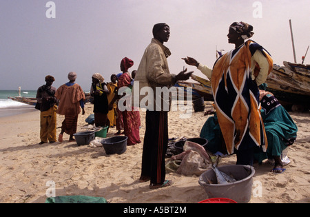 Pêcheur mauritanien trading avec des femmes en costume traditionnel sur la plage de Nouakchott, Mauritanie, Afrique Banque D'Images