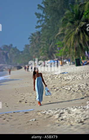 Femme en robe bleue longue promenades tôt le matin sur la plage de Lamai Ko Samui Island Thailand Banque D'Images