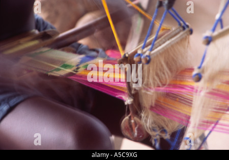 Jeune garçon tissage Kente cloth, près de Kumasi, Ghana, Afrique de l'Ouest. Blurred motion. Banque D'Images