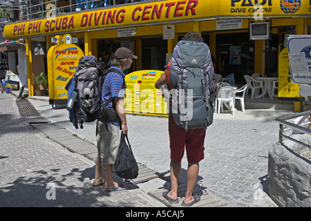 Backpackers regarder les annonces plongée le long du chemin derrière Ao Ton Sai beach île de Phi Phi, Thaïlande Banque D'Images