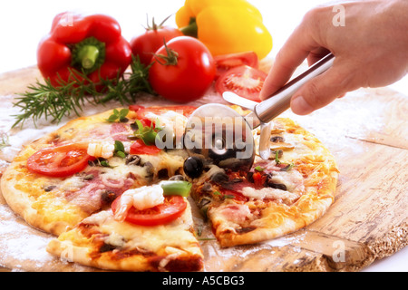 Man slicing pizza à la coupe de roue Banque D'Images