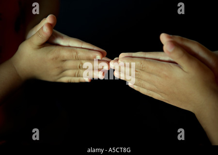 Les mains des enfants avec un fond noir Banque D'Images