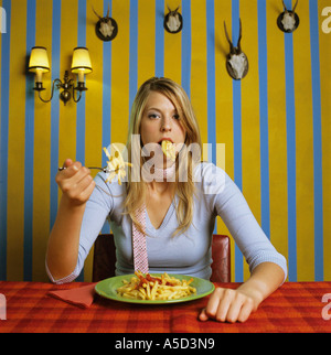 Young woman eating french fries Banque D'Images