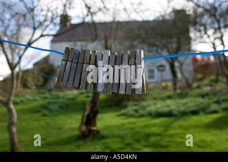Rangée de chevilles en bois patiné sur corde à linge à l'extérieur de la maison llangwyrfon West Wales UK Banque D'Images