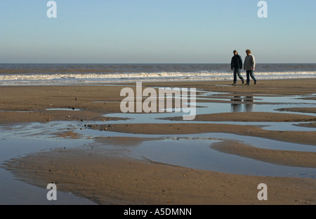 Deux femelles à marcher ensemble sur une plage en hiver Banque D'Images