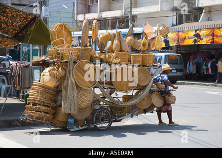 Vendeur de rue vendant des conteneurs en osier, des objets de Wickerwork, des brindilles tressées ou tissées ou des chaises et des meubles de rosiers attachés à la bicyclette, Krabi Town, Thaïlande Banque D'Images