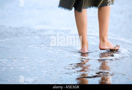 La femme joue dans la mer sur la plage. Banque D'Images