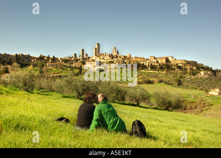 San Gimignano Toscane Italie Couple pique-nique sur l'herbe verte contre le panorama des nombreuses tours de l'horizontale Banque D'Images