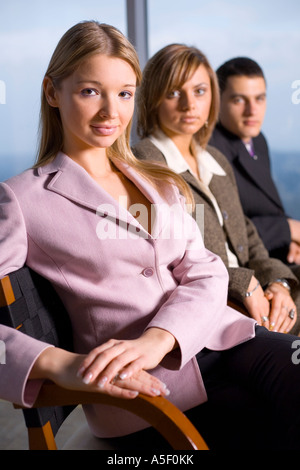 Groupe de personnes regardant la caméra se concentrer sur le visage de la première personne s'il n'y Grande fenêtre avec vue sur la grande ville derrière eux Banque D'Images