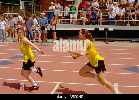 Coéquipiers passant baton dans high school course de relais de la voie à l'âge de 16 ans. St Paul Minnesota USA Banque D'Images