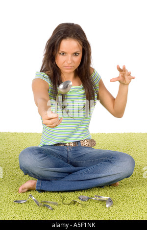 Femme est assise sur le tapis par l'esprit de flexion force cuillère Banque D'Images