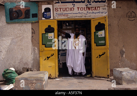 Un homme debout en face d'un studio photo à Nouakchott Mauritanie Banque D'Images