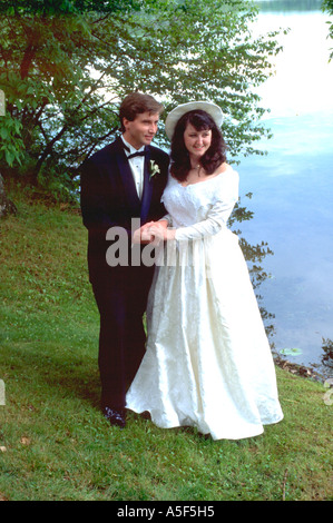Bride and Groom holding hands par Roy lac après la cérémonie du mariage l'âge de 25 ans. Minnesota USA Nisswa Banque D'Images