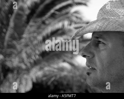 Homme dans un chapeau de paille au soleil en noir et blanc Banque D'Images