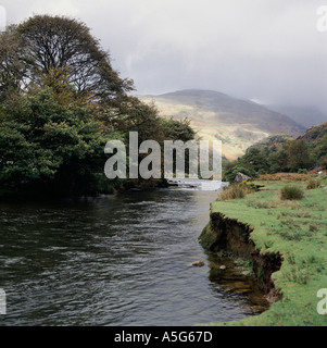 Vue sur rivière de montagne dans la moitié du soleil avec les montagnes derrière le Snowdonia au Pays de Galles Banque D'Images