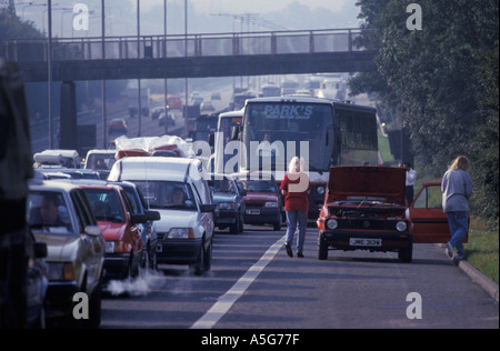 Pare-chocs à pare-chocs autoroutes embouteillages lignes de voitures coincées dans un embouteillage sur la M1 deux personnes avec la voiture en panne 2020s 2021 UK HOMER SYKES Banque D'Images