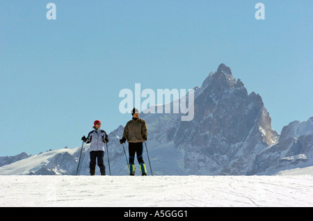 Skieurs sur les pistes au-dessus de la station de ski de l'Alpe d ' Huez, dans les Alpes françaises. Banque D'Images