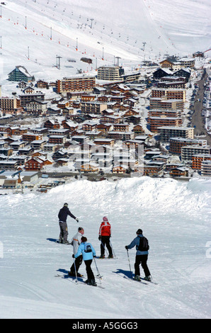 Skieurs sur les pistes au-dessus de la station de ski de l'Alpe d ' Huez, dans les Alpes françaises. Banque D'Images