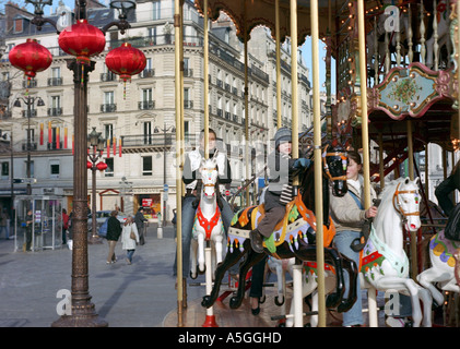 Les gens profiter d'une balade sur un merry go round lors d'un matin d'hiver ensoleillé à Paris Banque D'Images