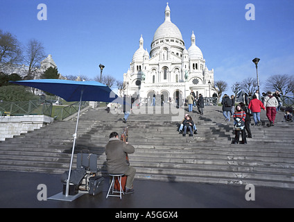 Un joueur reçoit les touristes et les visiteurs de la basilique du Sacré-Cœur à Montmartre une région historique et une destination touristique Banque D'Images