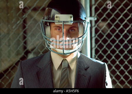 Businessman wearing american football helmet Banque D'Images