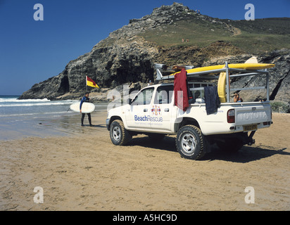 Surfer et véhicule de patrouille de sauvetage à Chapel Porth, sur la côte nord de Cornwall, UK Banque D'Images