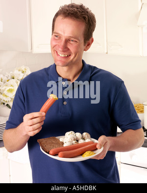 L'HOMME À MANGER CUISINE SALADE DE POMMES DE TERRE ET SAUCISSES Banque D'Images