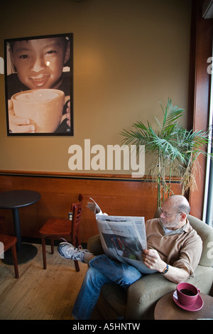 La Royal Oak Michigan un homme lit un journal à Sweetwaters Cafe un coffee shop Banque D'Images