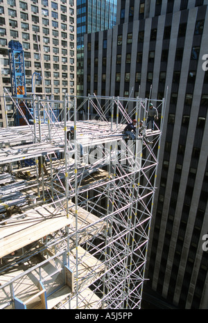 Travailleurs construisent la tour de levage utilisés pour les travailleurs et des fournitures pour la construction de maisons au hasard à 1745 Broadway à New York City. Banque D'Images