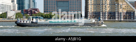 Tamise barge Bateau banner favorise le déplacement du ciment en vrac pour sauver Readymix camion camion transport routier passe Canary Wharf East London Docklands UK Banque D'Images