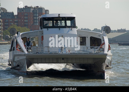 Catamaran bateau rivière & transport service touristique sur la Tamise près de Canary Wharf Pier avant de se diriger vers la ville de Londres Banque D'Images