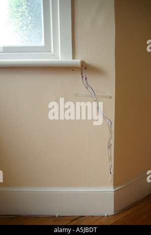 Chambre dommages intérieurs sur mur avec bande de verre collé au crack par compagnie d'assurance afin de surveiller d'autres mouvements Banque D'Images
