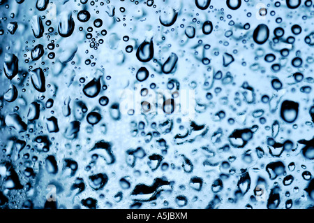 Close up gouttes d'eau sur une surface transparente et rétro-éclairées Banque D'Images