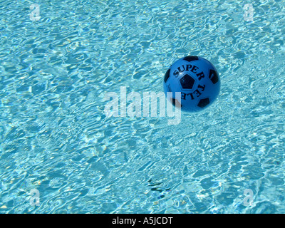 Football bleu floating in pool Banque D'Images